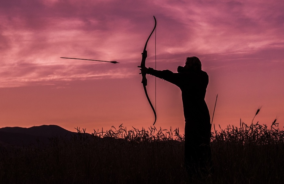 Silhouette of archer releasing arrow